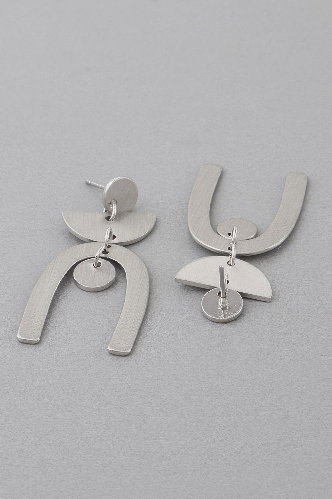 Golden Heir multi-shape gold arch drop earrings with geometric design, hanging elegantly against a neutral background.