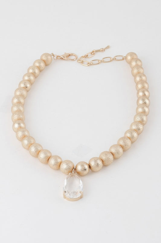 Golden Heir clear teardrop beaded necklace with gold accents, featuring elegant teardrop-shaped beads on a delicate chain.