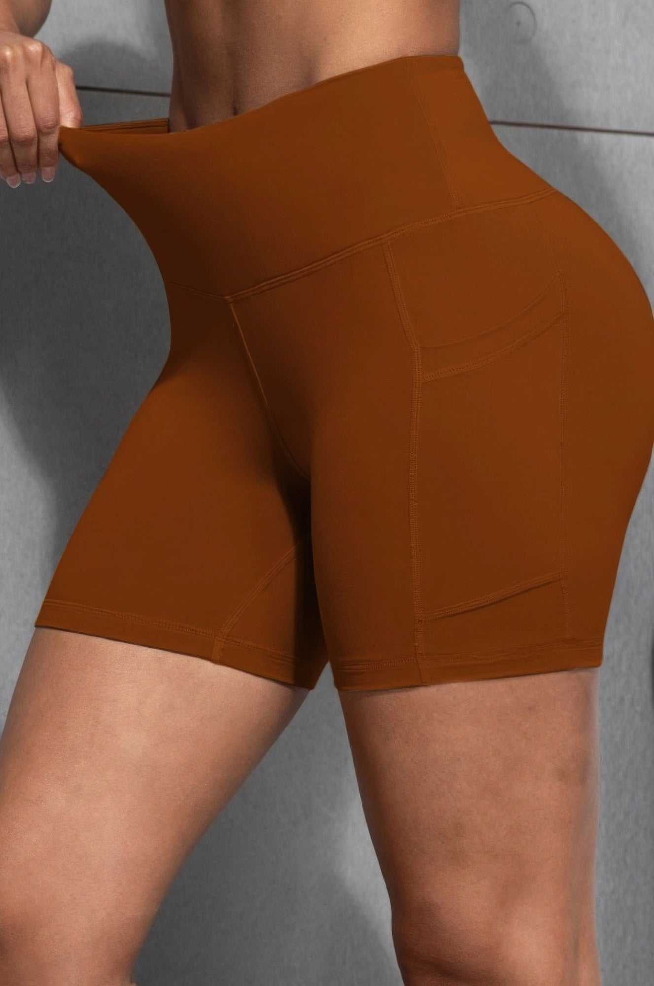 Orange Golden Heir sports yoga shorts with pockets, lightweight active shorts designed for comfort and flexibility during workouts.
