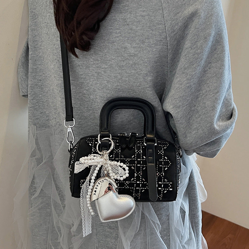 Black Korean-style minimalist cylindrical tote bag by Golden Heir with pendant detail and versatile design.