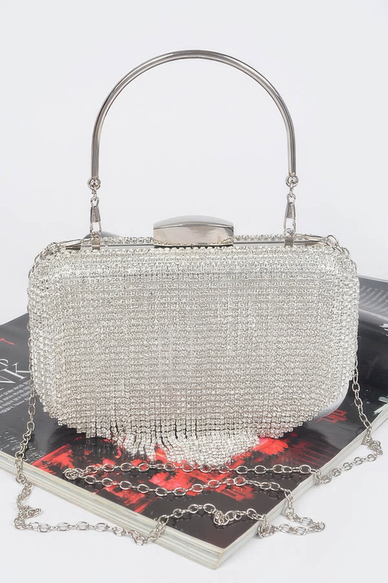 Golden Heir rhinestone fringe hard clutch bag with black background, featuring sparkling embellishments and elegant design.