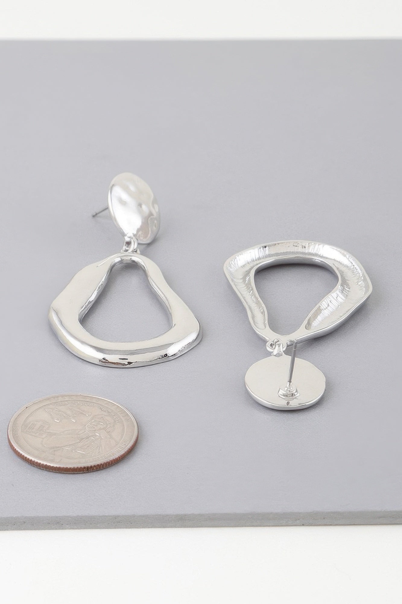 Golden Heir abstract shiny teardrop drop earrings in gold with a sleek, modern design and reflective finish.