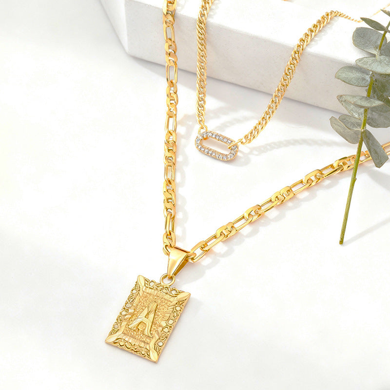 Golden Heir double-layer gold necklace featuring 26 letter pendants and zircon circle accents on a jewelry display.