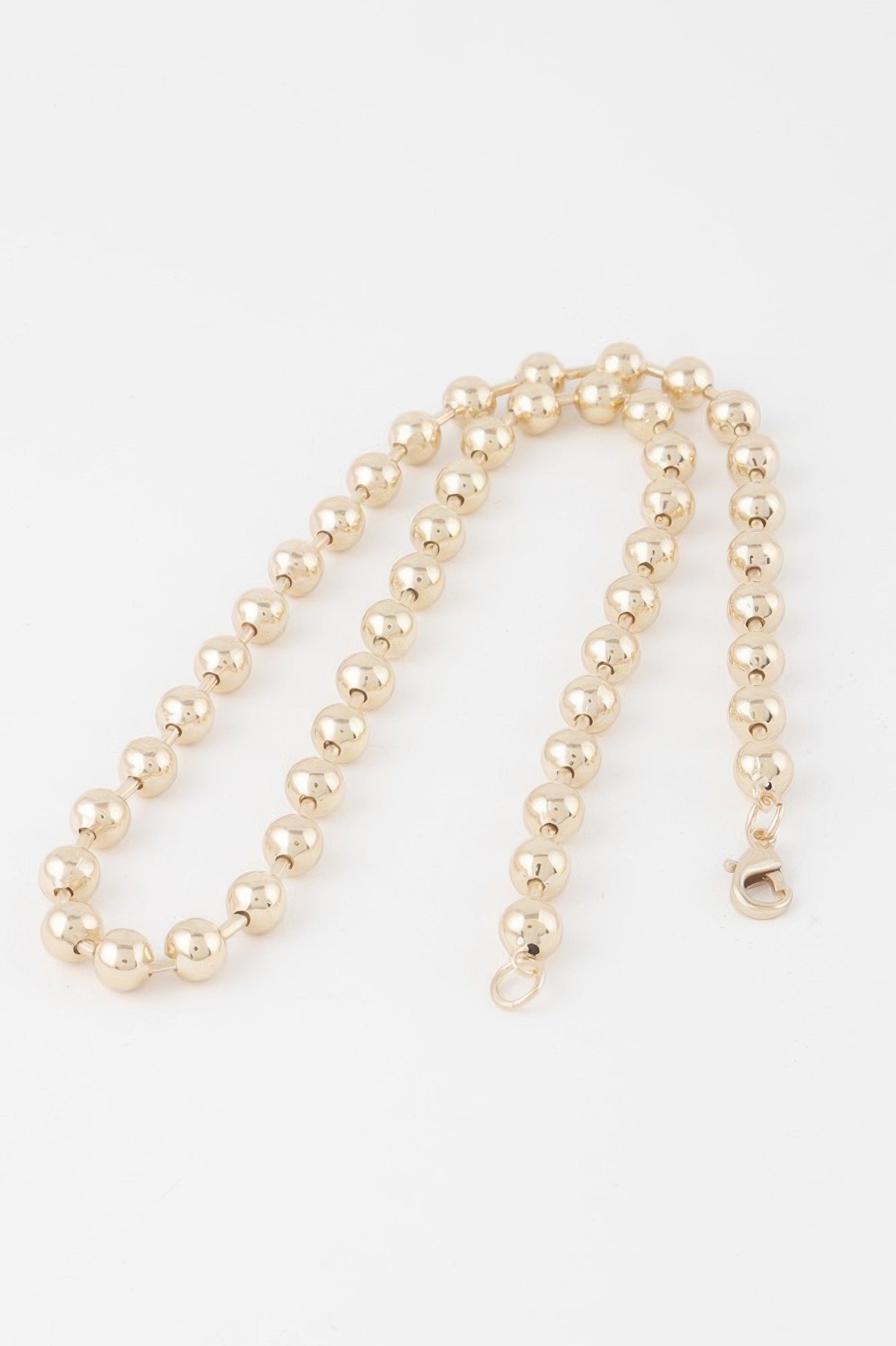 Golden Heir metal ball beaded short necklace featuring gold-toned beads and a stylish, elegant design.