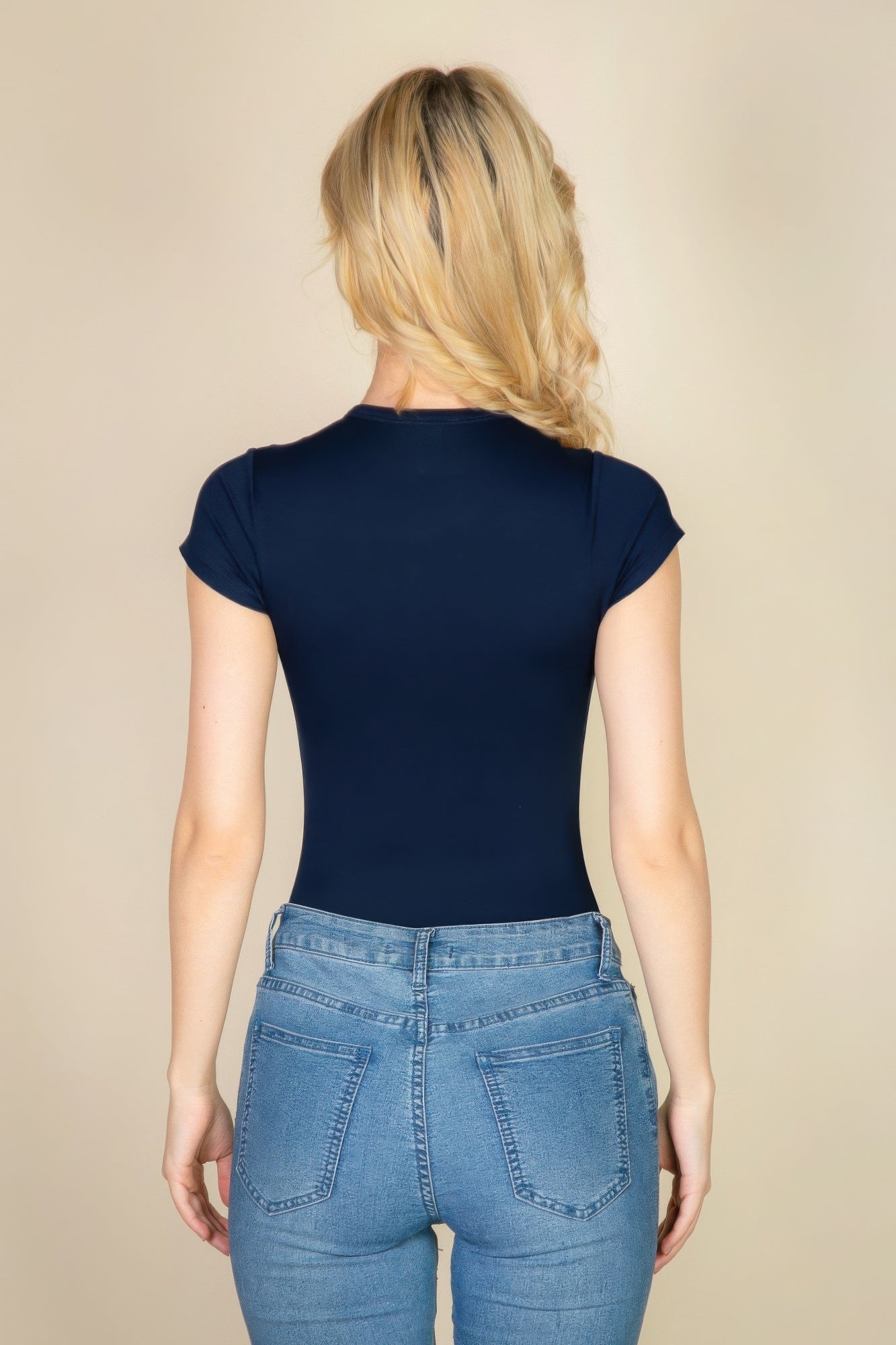 Black Golden Heir short sleeve crew neck bodysuit laid flat, showcasing its fitted design and soft fabric.
